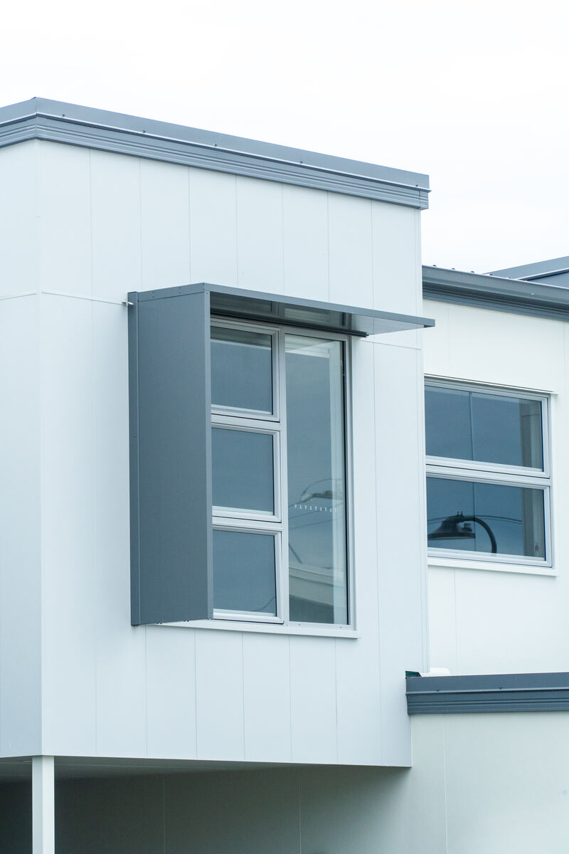 Completed townhouse with charcoal cladding and custom window awning
