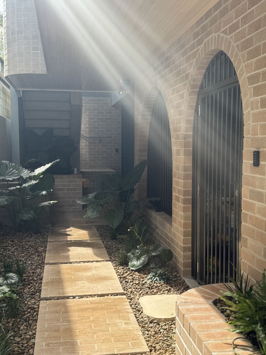 Renovated Queenslander entry with custom black aluminium security gate
