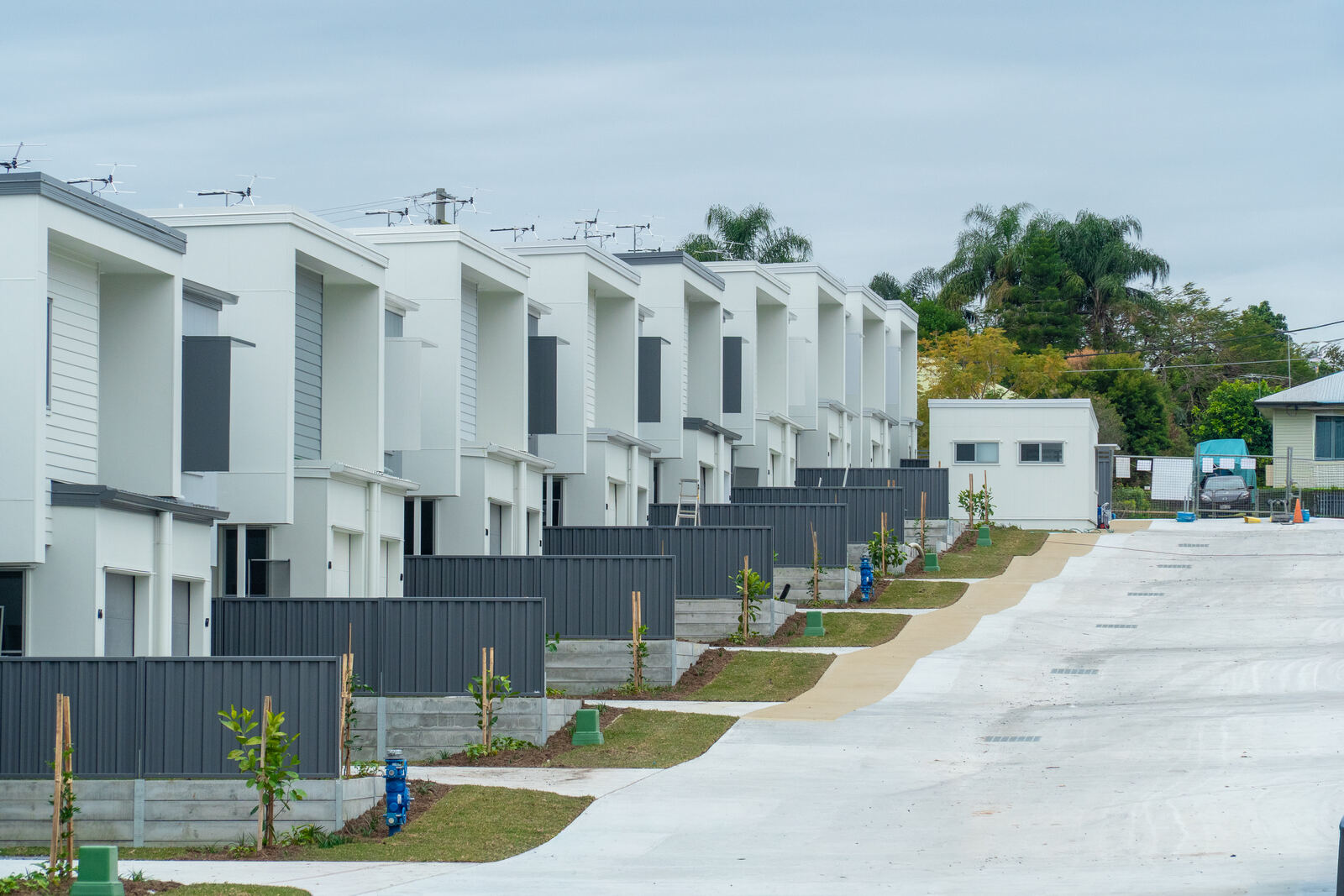 Row of completed townhouses with dark aluminium fencing, street view